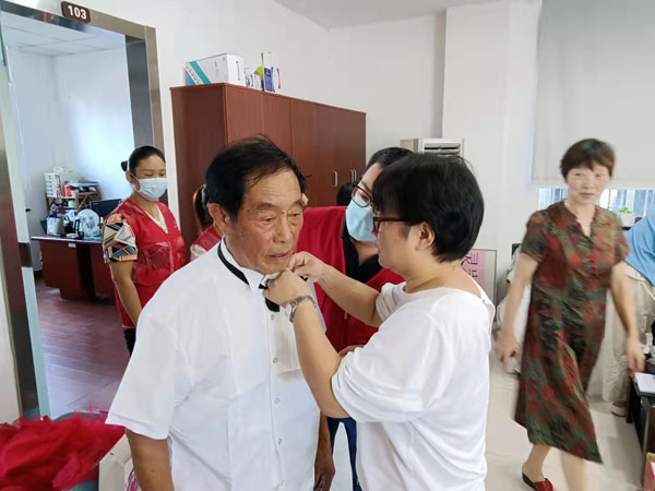 1639924499731262.jpg 正在幫居民整理領(lǐng)結(jié)的靈巖社區(qū)分院校長賀丹.jpg