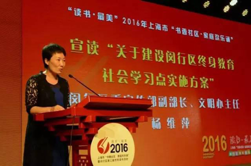 圖六：閔行區(qū)學(xué)促委副秘書長、區(qū)委宣傳部副部長、文明辦主任楊維萍宣讀《關(guān)于建設(shè)閔行區(qū)終身教育社會(huì)學(xué)習(xí)點(diǎn)的實(shí)施方案》.jpg